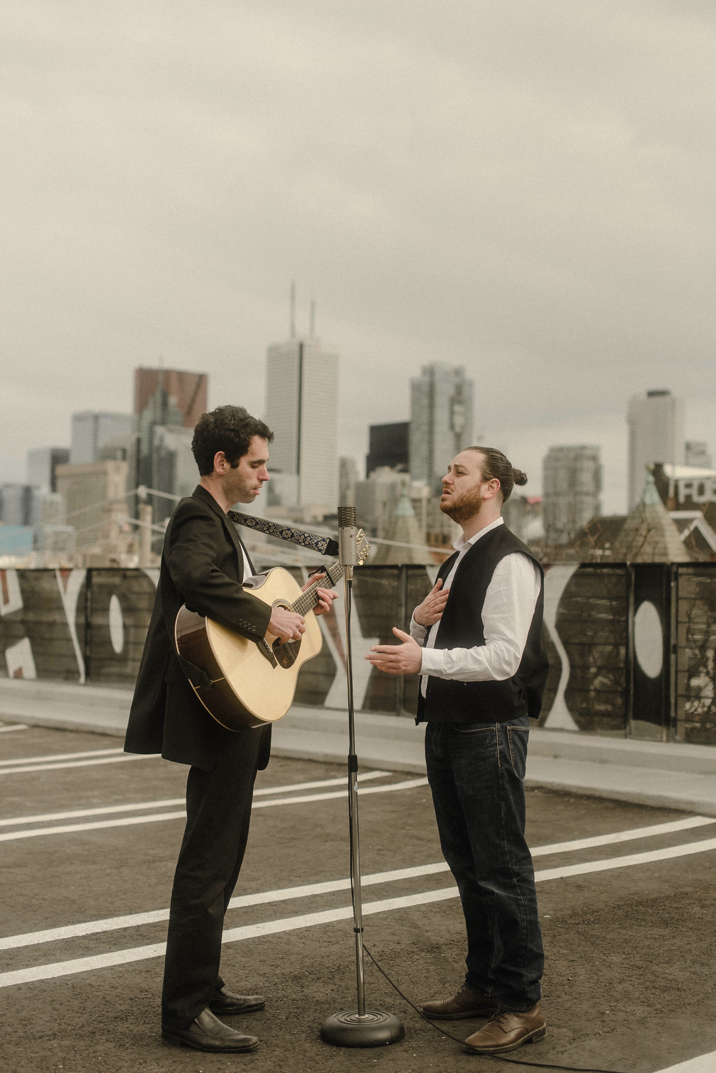 Danny and David of Old Friends standing together outdoors, one holding an acoustic guitar
